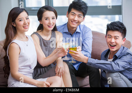 Glückliche junge Freunde trinken cocktail im Wohnzimmer Stockfoto