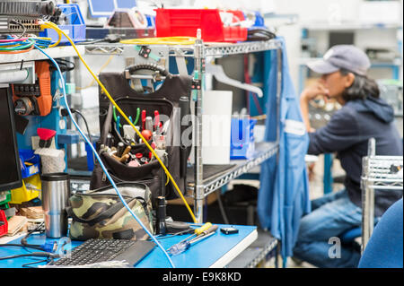 Werkzeuge auf Tisch mit männlichen Techniker im Hintergrund bei Elektronik-Industrie Stockfoto