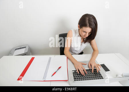 Erhöhte Ansicht der Geschäftsfrau mit Laptop am Schreibtisch im Büro Stockfoto