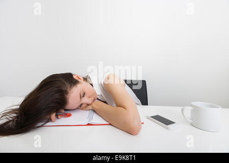 Müde Geschäftsfrau schlafen am Schreibtisch im Büro Stockfoto
