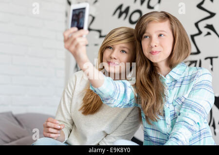 Nette Schwestern fotografieren mit Ihrem Smartphone zu Hause Stockfoto