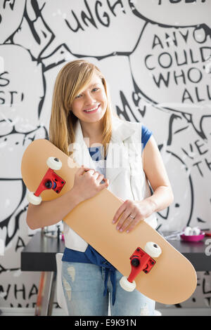 Porträt von glücklich Teenager-Mädchen halten Skateboard zu Hause Stockfoto
