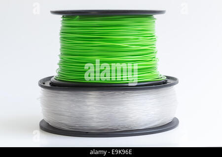 Filament für 3D Drucker kristallklar und leuchtend grün vor einem hellen Hintergrund. Stockfoto