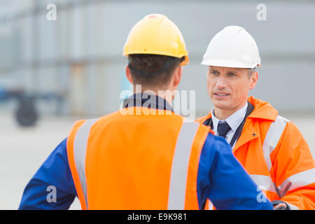 Arbeitnehmer im Frachthafen im Gespräch Stockfoto