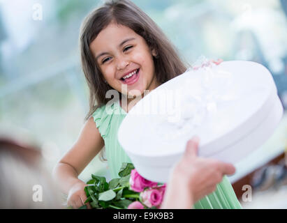 Porträt von netten Mädchen holding Box und Blumen-Geschenk-Korb zu Hause Stockfoto