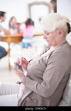 Seitenansicht des senior Frau mit digital-Tablette zu Hause Stockfoto