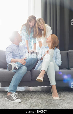 Glückliche Eltern mit Töchtern verbringen Zeit im Wohnzimmer Stockfoto