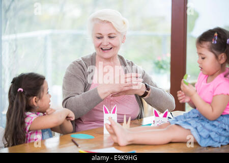 Ältere Frau Enkelinnen im Kunstwerk zu Hause unterstützen Stockfoto