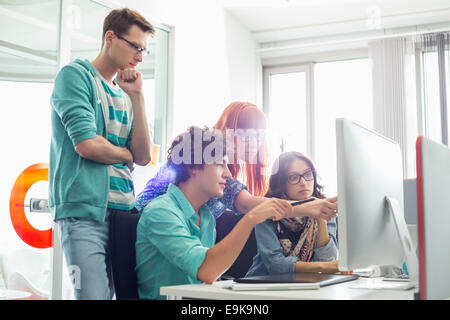 Kreative Kollegen diskutieren über Computer im Büro Stockfoto