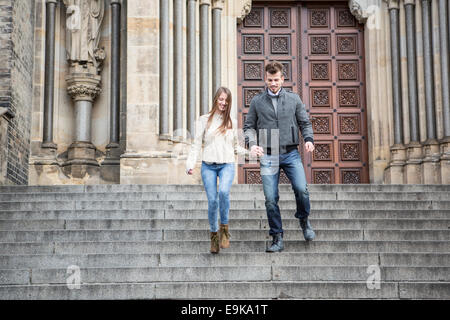 Volle Länge des jungen paar Treppenstufen gegen Gebäude bewegen Stockfoto