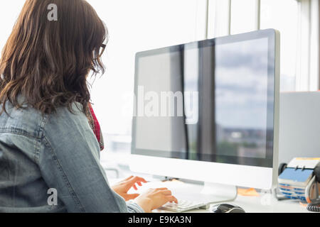 Rückansicht des Geschäftsfrau mit Desktop-Computer im Kreativbüro Stockfoto