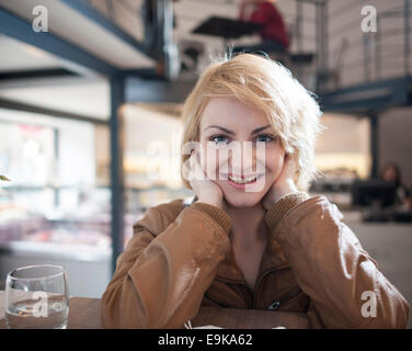 Porträt der schönen jungen Frau lächelnd in café Stockfoto