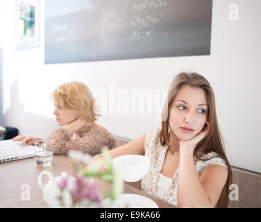 Nachdenkliche junge Frau mit Kaffee im café Stockfoto