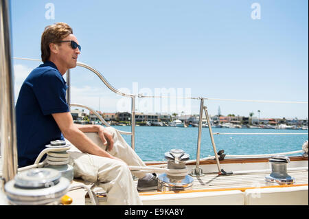 Full-length Seitenansicht der Mann sitzt auf yacht Stockfoto