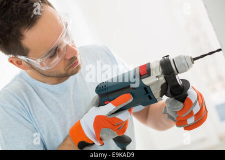 Mid-Adult Mann in die Wand bohren Stockfoto