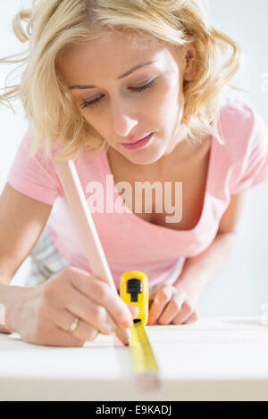 Schöne Frau Kennzeichnung Tisch mit Maßband Stockfoto