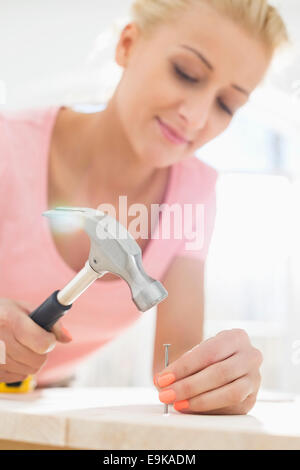 Mid-Adult Woman Nagelung in Tabelle Stockfoto