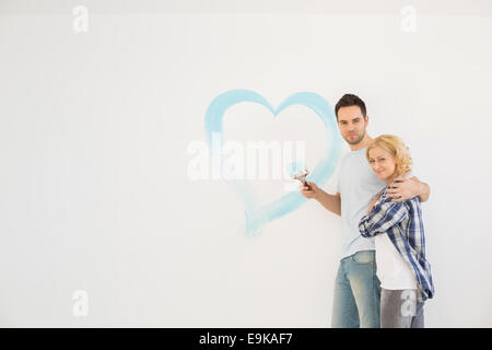 Porträt des mittleren Erwachsenenalter Liebespaar mit gemalten Herzen an Wand Stockfoto