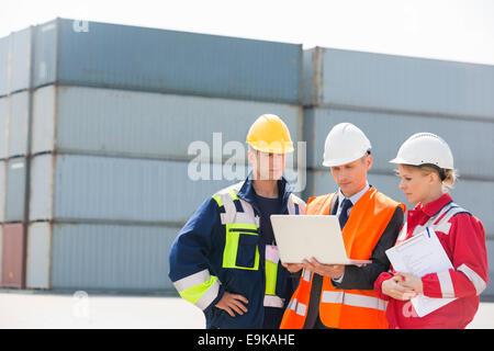 Arbeitnehmer über Laptop im Frachthafen diskutieren Stockfoto