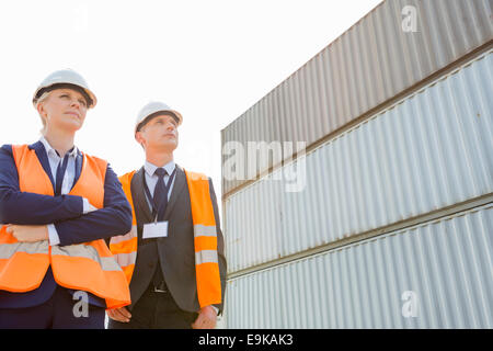 Niedrigen Winkel Ansicht von Arbeitnehmern gegen Frachtcontainer Stockfoto