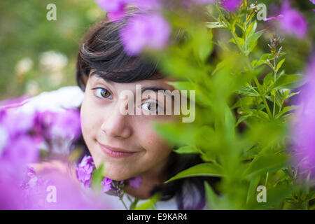 Close-up Portrait eines jungen Mädchens im Garten zwischen den Blumen. Stockfoto