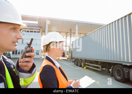 Männliche und weibliche Arbeitnehmer, die im Frachthafen Stockfoto