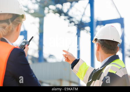 Männliche und weibliche Arbeitnehmer, die im Frachthafen Stockfoto