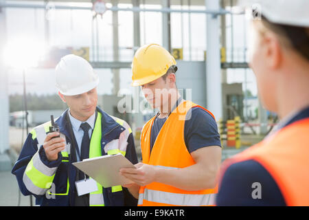 Arbeitnehmer über Zwischenablage im Frachthafen diskutieren Stockfoto