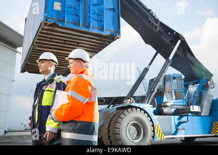 Arbeitnehmerinnen und Arbeitnehmer durch LKW im Frachthafen stehen Stockfoto