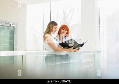 Geschäftsfrauen diskutieren über Dateiordner im Büro Stockfoto