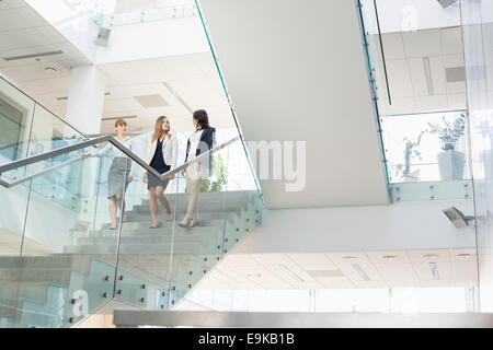 Unternehmerinnen im Gespräch während der Bewegung nach unten Schritte im Büro Stockfoto