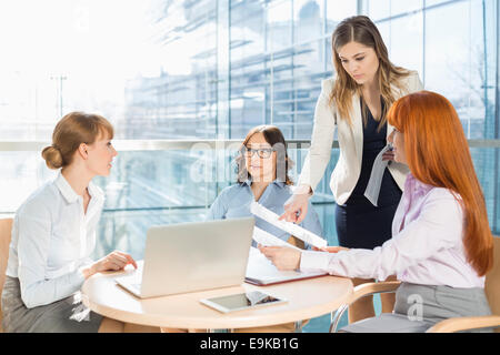 Geschäftsfrauen diskutieren über Dokumente am Tisch im Büro Stockfoto