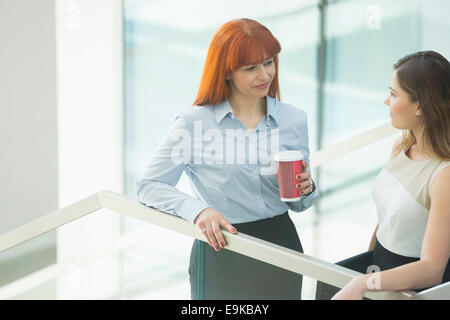 Unternehmerinnen im Gespräch bei Kaffee im Büro Stockfoto