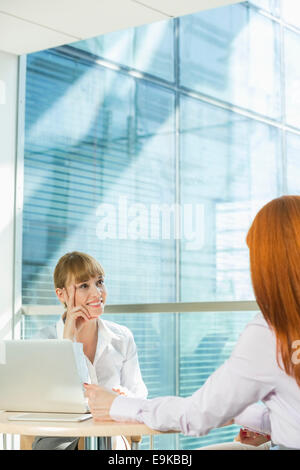 Geschäftsfrauen diskutieren am Tisch im Büro Stockfoto