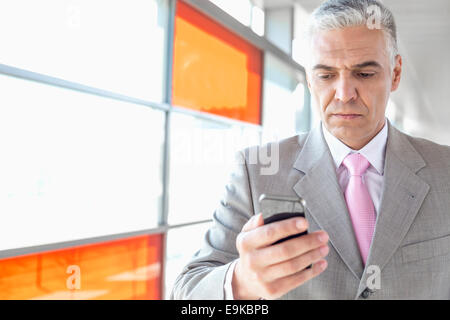 Applying Geschäftsmann mit Smartphone am Bahnhof Stockfoto