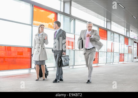 Geschäftsleute, die zu Fuß, während die männlichen Kollegen hetzen im Bahnhof Stockfoto