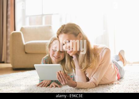 Mutter und Tochter mit digital-Tablette auf Boden zu Hause Stockfoto