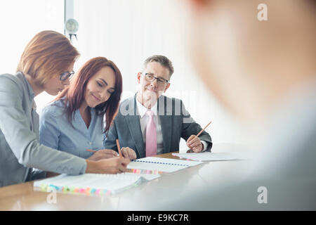 Geschäftsleute, die gemeinsam am Konferenztisch Stockfoto