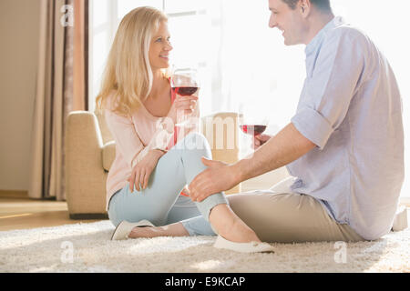 Liebespaar sahen einander beim Trinken von Rotwein zu Hause Stockfoto