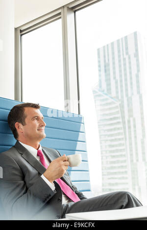 Reife Geschäftsmann Kaffeetrinken im Büro Stockfoto