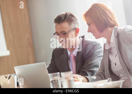 Unternehmer und Unternehmerin diskutieren während dem Mittagessen im Büro Stockfoto