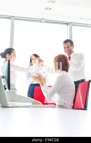 Geschäftsleute, die Erfolge im Büro feiern Stockfoto