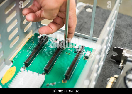 Bild des männlichen Techniker reparieren PCI-Steckplätze im Computer Fabrik beschnitten Stockfoto