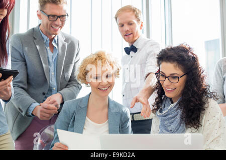 Glücklich Geschäftsleute arbeiten am Laptop in Kreativbüro Stockfoto