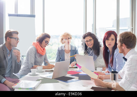 Diskutieren über Fotografien am Konferenztisch in Kreativbüro Geschäftskollegen Stockfoto