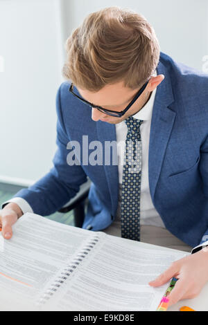 Kreative Geschäftsmann lesen Datei am Schreibtisch im Büro Stockfoto