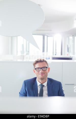 Porträt von zuversichtlich Geschäftsmann mit Sprechblase im Büro