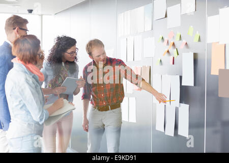 Junger Geschäftsmann Dokument, Kolleginnen und Kollegen im Kreativbüro zu erklären Stockfoto