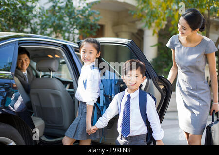 Junges Paar, die ihre Kinder zur Schule schicken Stockfoto