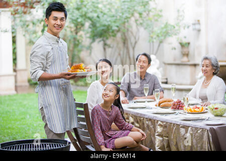 Junger Mann für seine Familien Grillen Stockfoto